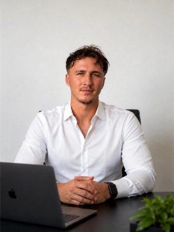 Tyler Kohler, assis à son bureau, les mains jointes devant un ordinateur portable.